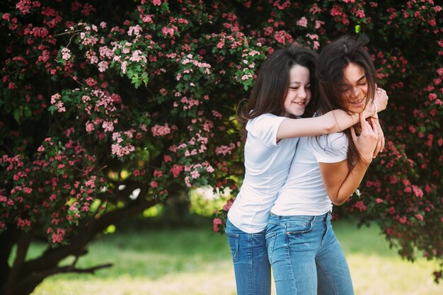 Due ragazze che indossano abiti simili abbracciati all&#39;esterno