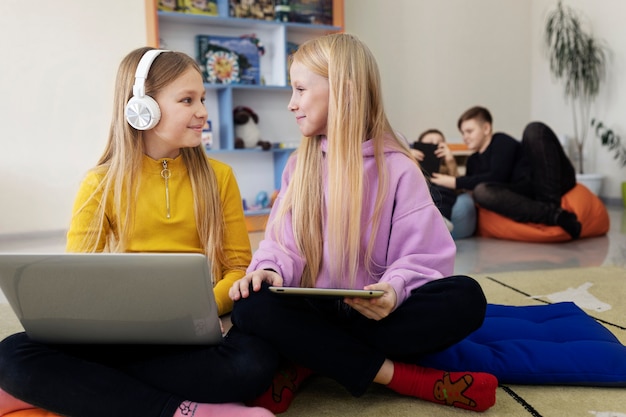 Due ragazze che lavorano insieme usando il loro laptop e tablet