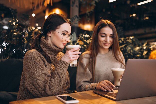 Due ragazze che lavorano su un computer in un caffè