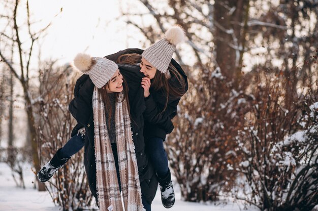 Due ragazze gemelli insieme nel parco di inverno