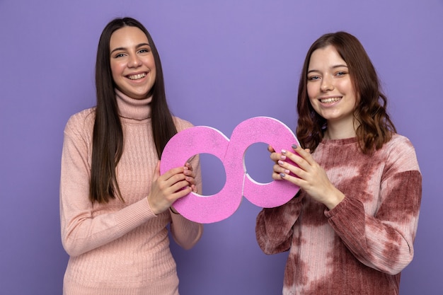 Due ragazze sorridenti nella felice festa della donna che tengono il numero otto