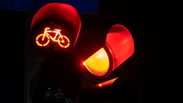 Due semafori rossi con il logo della bicicletta su uno di notte a Bucarest, in Romania