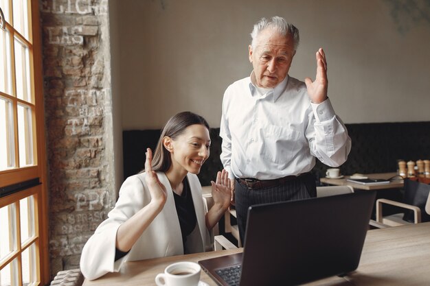 Due soci d'affari che lavorano con un computer portatile in un caffè