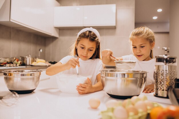 Due sorelle delle bambine che cucinano alla cucina