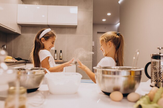 Due sorelle delle bambine che cucinano alla cucina