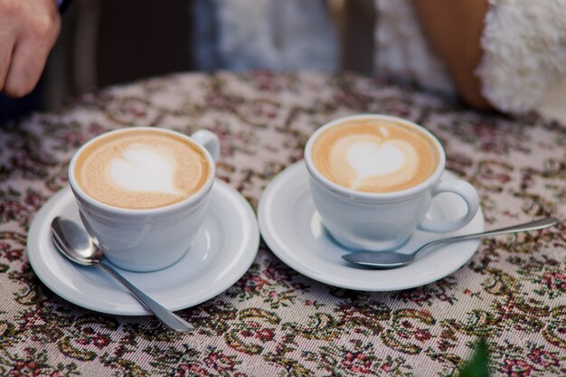 Due tazze di caffè con latte stanno sul tavolo