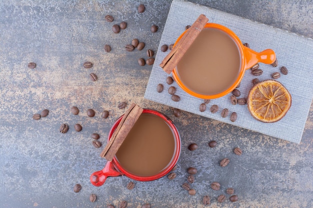 Due tazze di caffè, libro e chicchi di caffè sul tavolo di pietra. Foto di alta qualità