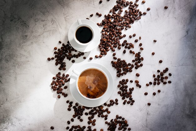 Due tazze di caffè visto da sopra e chicchi di caffè intorno