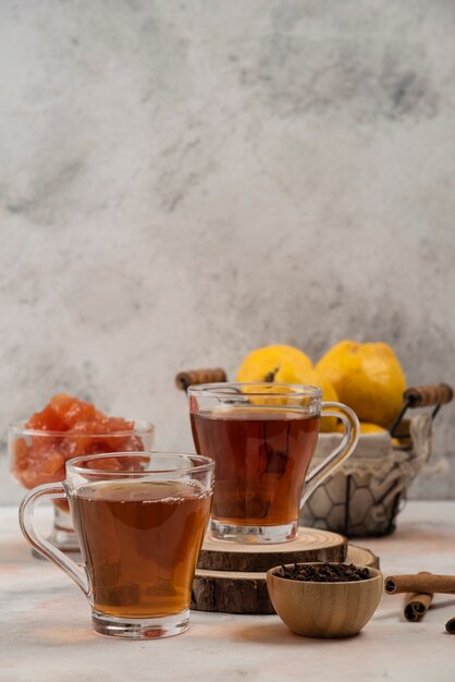 Due tazze di tè caldo con marmellata sul tavolo di marmo.