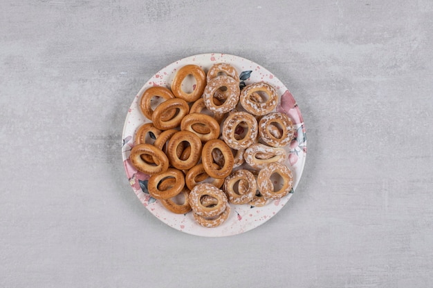 Due tipi di gustosi anelli pretzel sul piatto bianco.