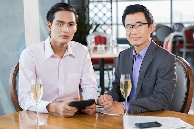 Due uomini d&#39;affari asiatici con bicchieri di champagne