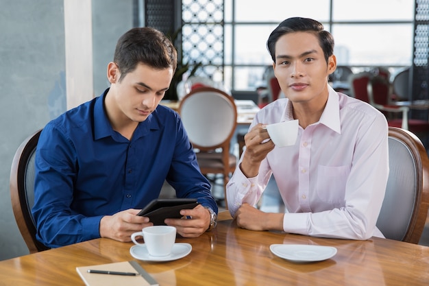 Due uomini d&#39;affari di lavoro e bere il caffè