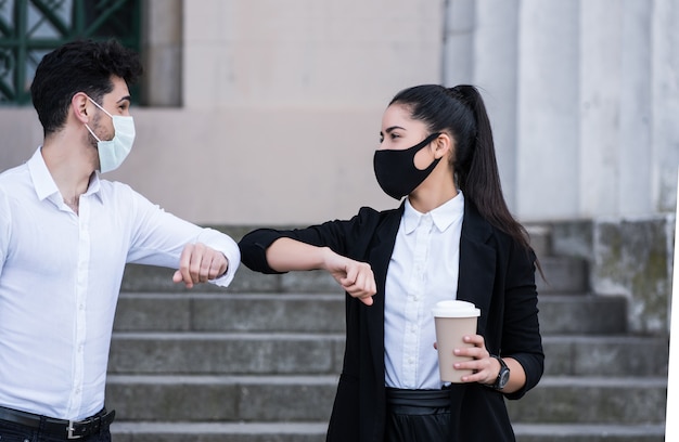 Due uomini d'affari urtando i gomiti per salutarsi all'aperto. Concetto di affari. Nuovo stile di vita normale.