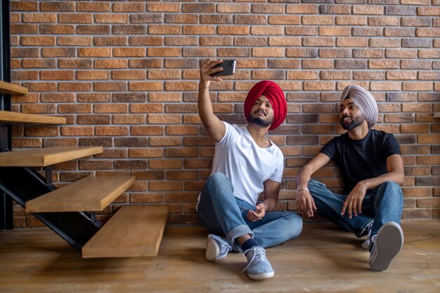 Due uomini indiani in turbante che fanno selfie