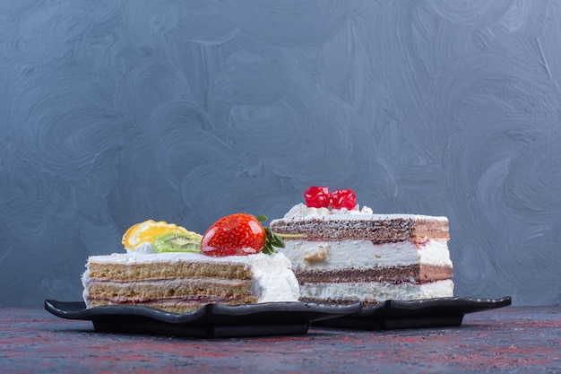 Due vassoi con fette di torta sul tavolo astratto.