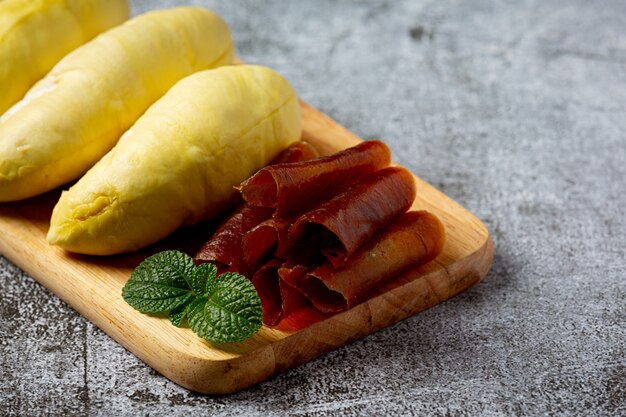 Durian e snack sulla superficie scura.