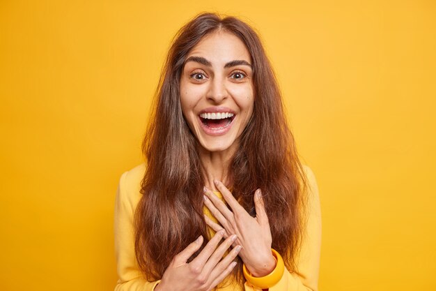 Eccitata donna europea felice con i capelli lunghi naturali sorrisi sente ampiamente notizie eccellenti