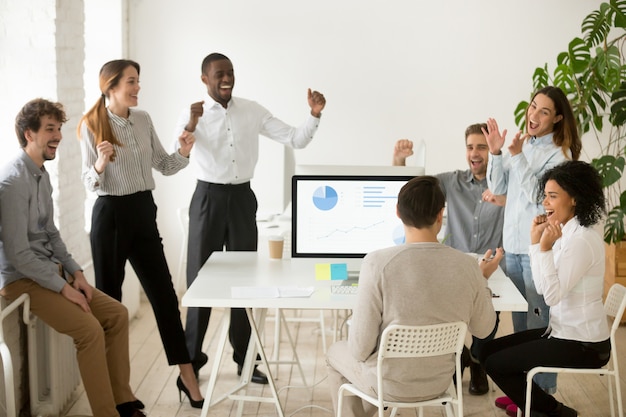 Eccitato da buone notizie, colleghi motivati che celebrano insieme il successo aziendale