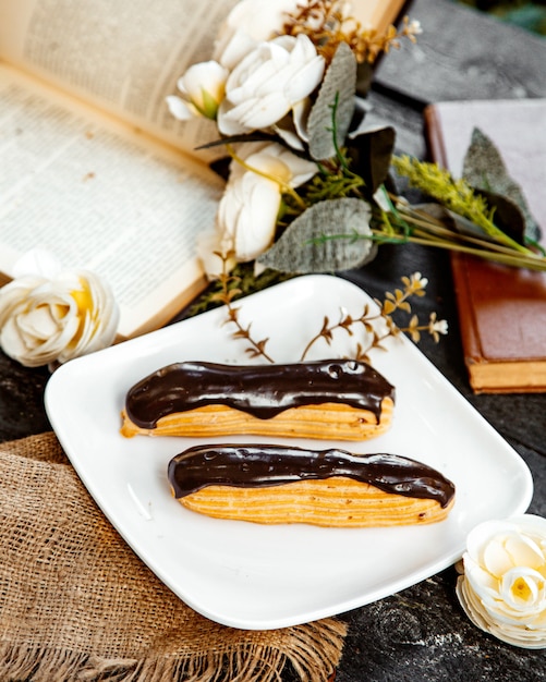 Eclairs di cioccolato zuccherato su un piatto