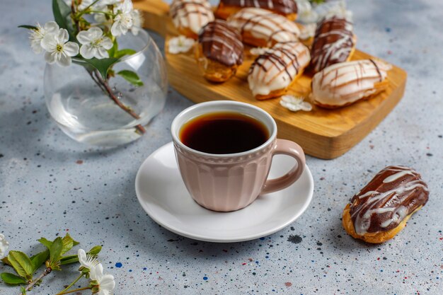 Eclairs o profiteroles con cioccolato nero e cioccolato bianco con crema pasticcera dentro, dessert francese tradizionale vista dall'alto.