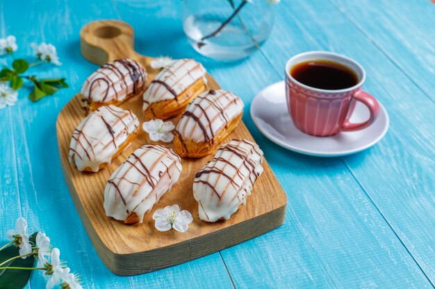 Eclairs o profiteroles con cioccolato nero e cioccolato bianco con crema pasticcera dentro, dessert francese tradizionale vista dall'alto.