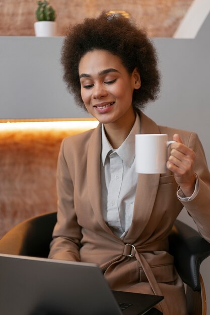 Economista femminile del colpo medio che lavora al computer portatile