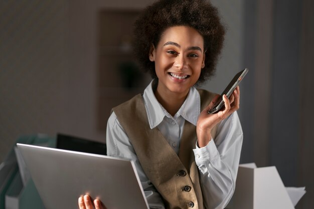 Economista femminile del colpo medio che lavora al computer portatile