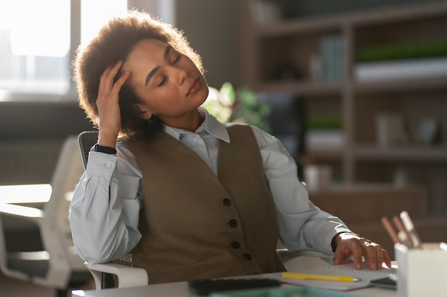 Economista femminile del colpo medio che lavora nell'ufficio