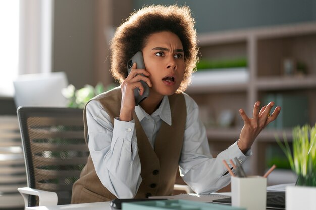 Economista femminile del colpo medio che tiene smartphone