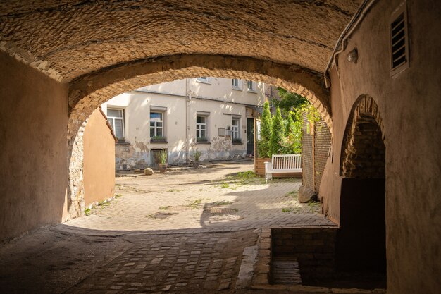 Edificio ad arco circondato da appartamenti e verde sotto la luce del sole durante il giorno