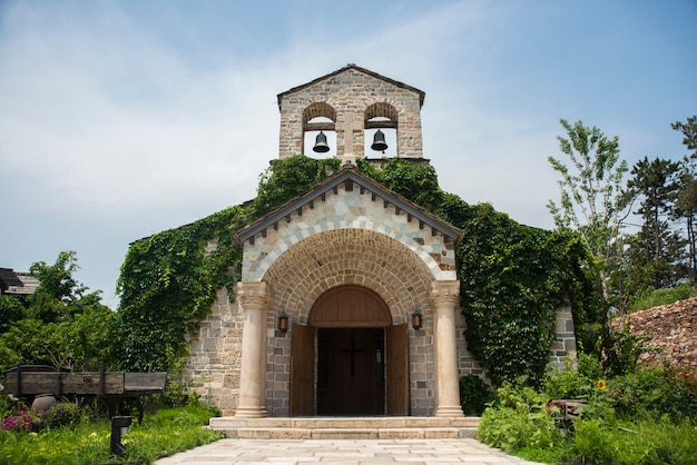 Edificio di chiesa medievale con due campane squillanti nella parte superiore