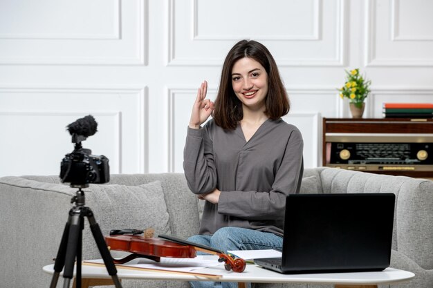 Elearning carina giovane bella ragazza a distanza a casa dando lezioni di violino dicendo ciao