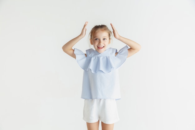 Elegante bambina sorridente in posa in abiti casual isolati su bianco studio