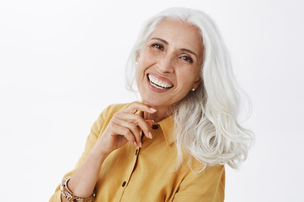 Elegante bella donna senior con capelli grigi sorridendo felice