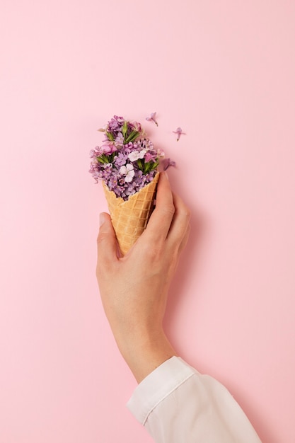 Elegante concetto di cibo ecologico con fiori in cono gelato