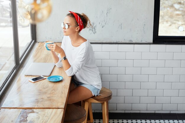 Elegante donna che indossa bandana seduto nella caffetteria