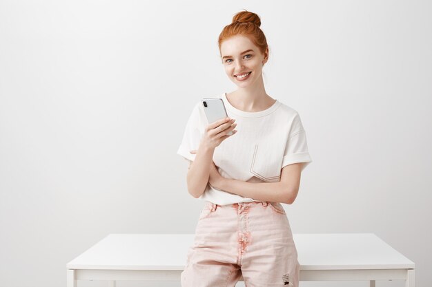 Elegante donna con i capelli rossi utilizzando il telefono cellulare