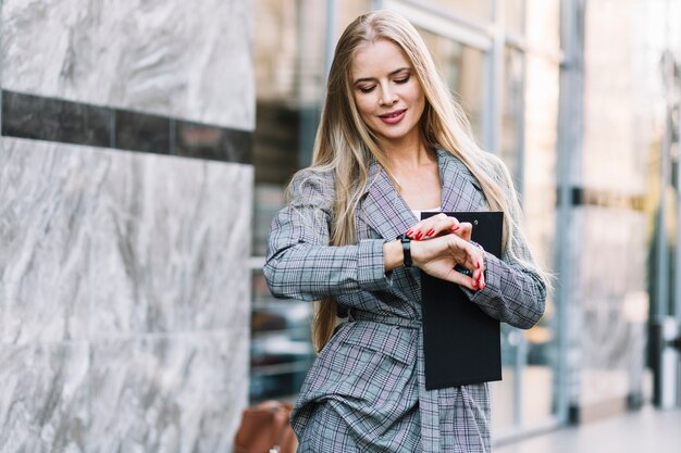 Elegante donna d&#39;affari guardando orologio