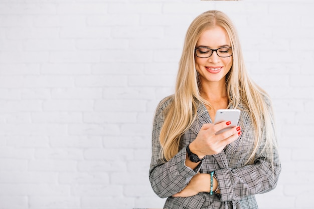 Elegante donna d&#39;affari utilizzando uno smartphone