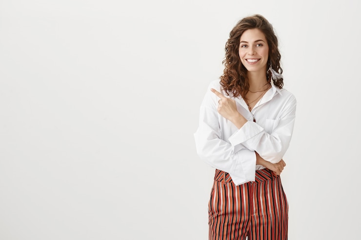 Foto gratuito elegante donna di successo che punta a sinistra e sorridente
