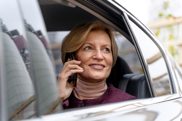 Elegante donna matura seduta in un taxi