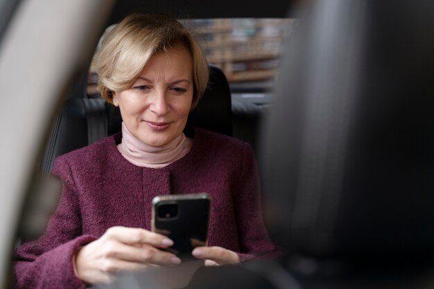 Elegante donna matura seduta in un taxi