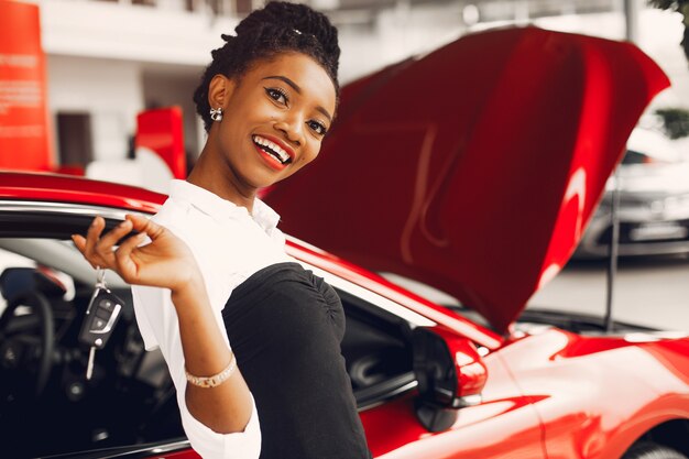 Elegante donna nera in un salone di auto
