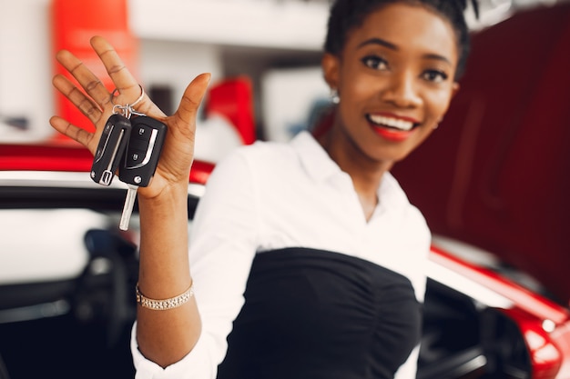 Elegante donna nera in un salone di auto