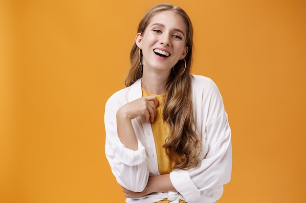 Elegante donna spensierata assertiva e sicura di sé che si veste alla festa ridendo gioiosamente divertendosi e...