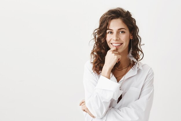 Elegante donna splendida sorridente, che sembra interessata