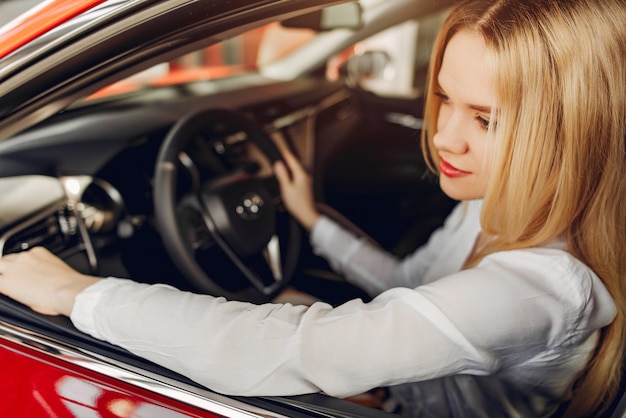 Elegante ed elegante donna in un salone di auto