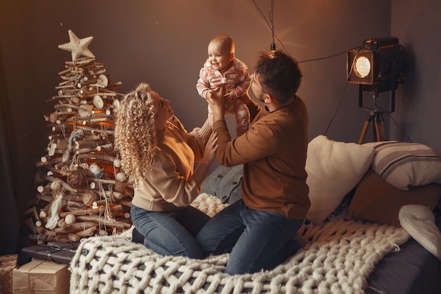 Elegante famiglia seduta a casa vicino all'albero di Natale