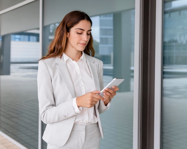 Elegante imprenditrice utilizza lo smartphone all'aperto