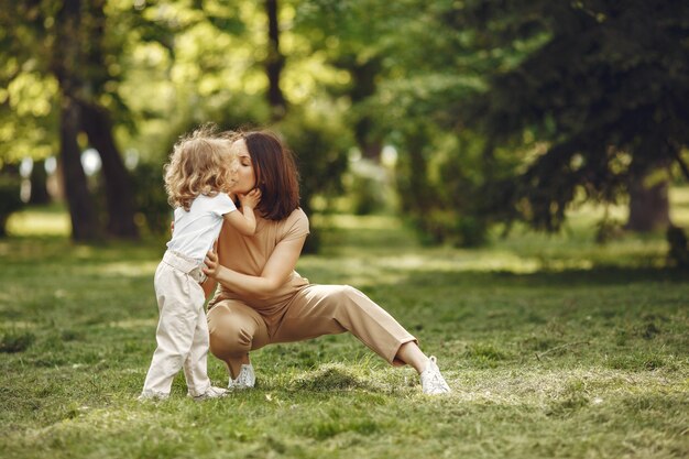 Elegante madre con figlia in una foresta estiva